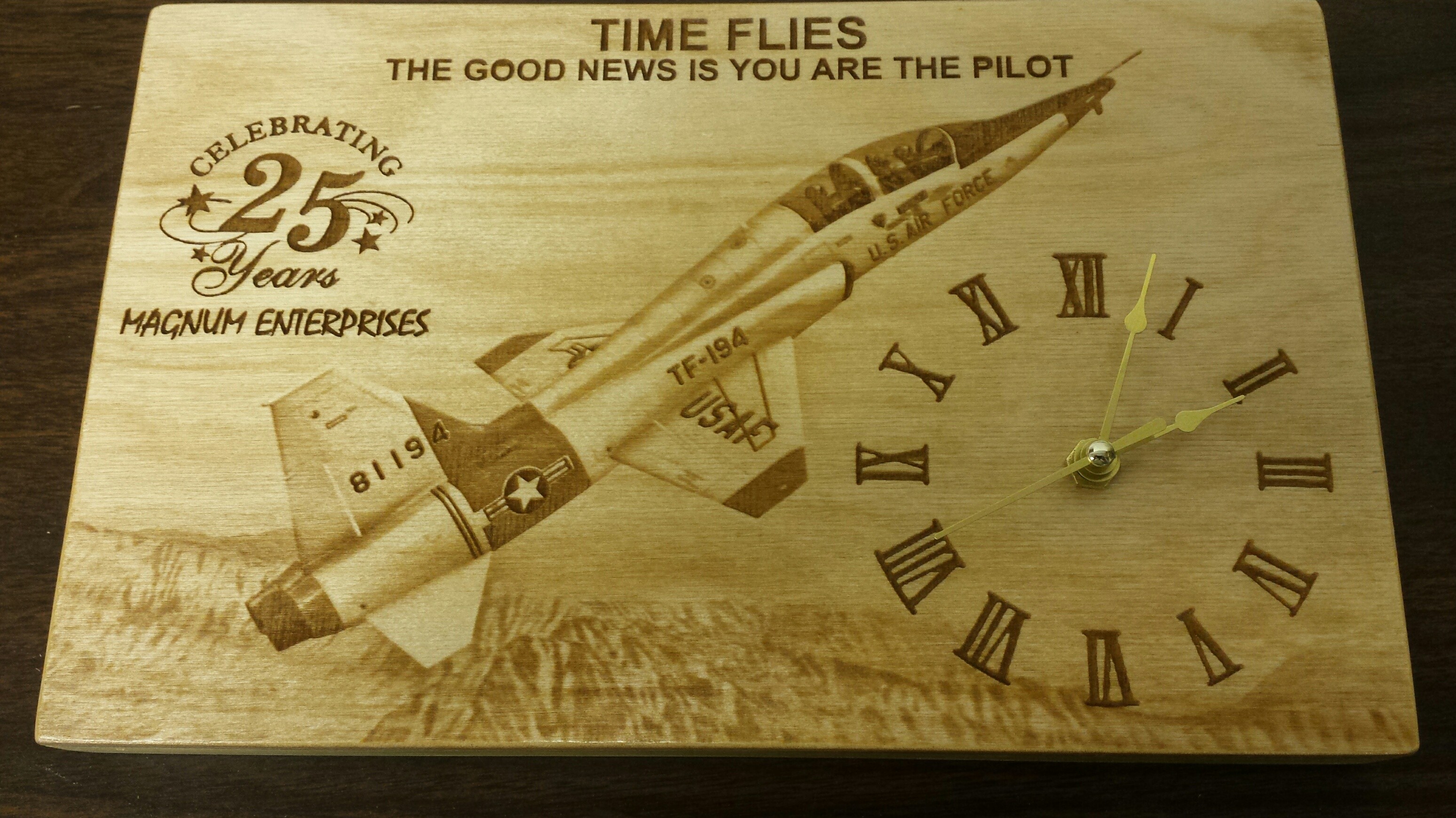 Engraved wooden clock featuring a T-38 aircraft, Roman numerals and a 25 year anniversary inscription
