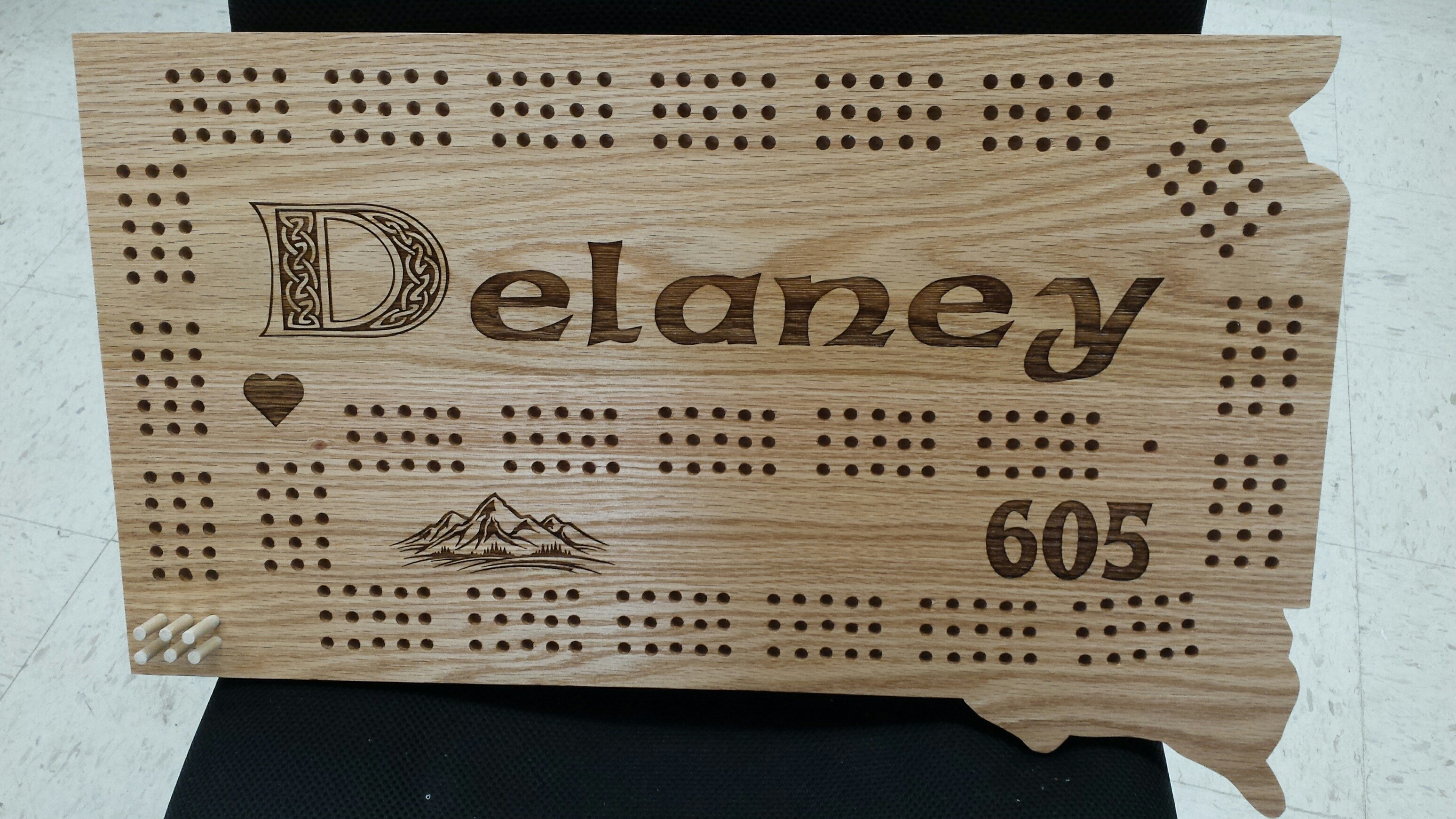 South Dakota shaped wooden cribbage board engraved with the name Delaney and 605