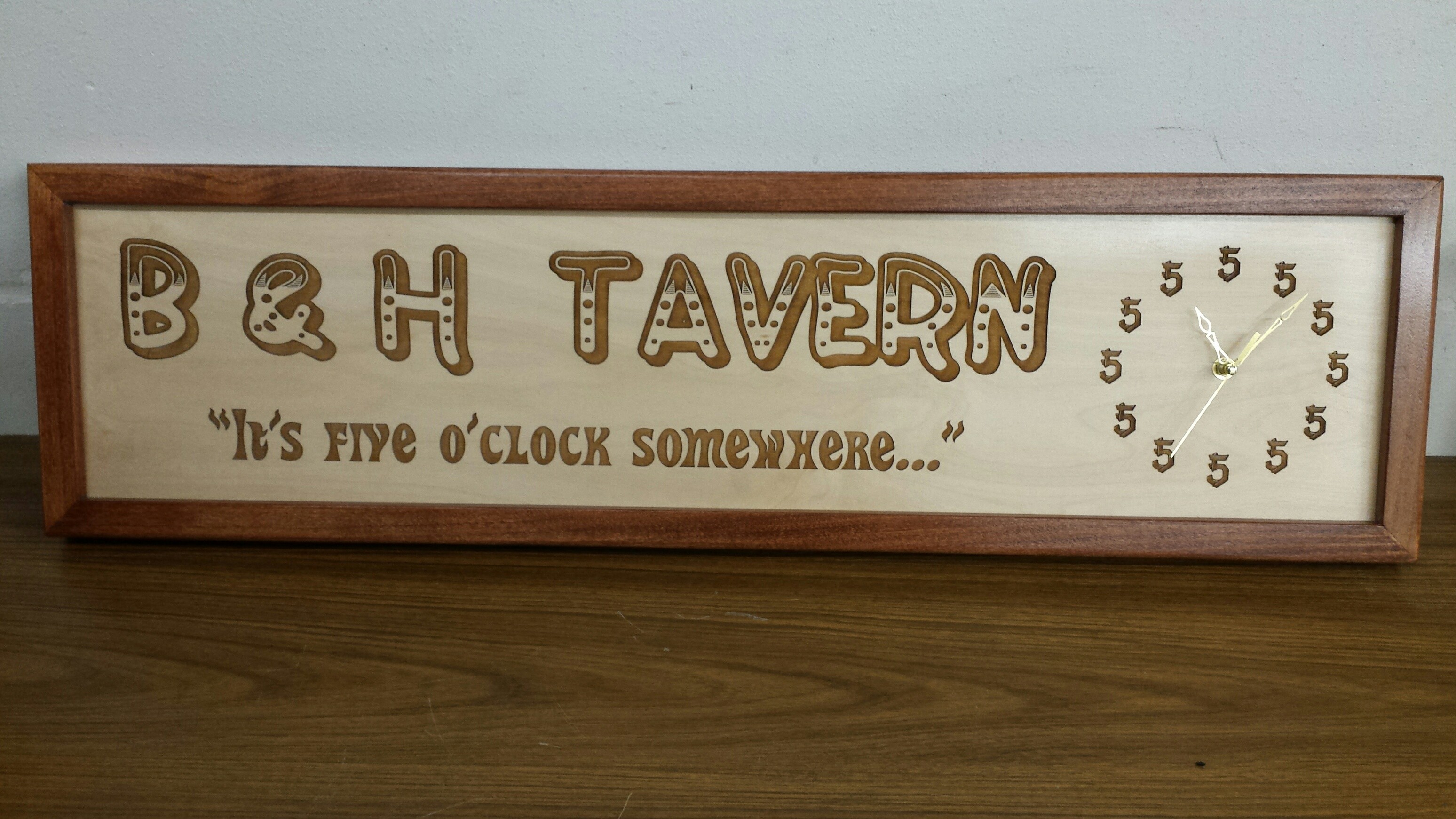 Framed wooden B and H Tavern sign with custom engraved lettering and a clock